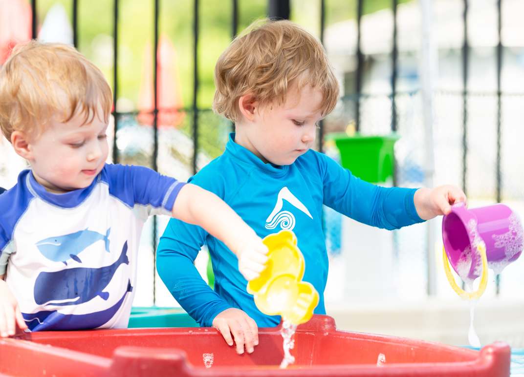 Young children playing in water.