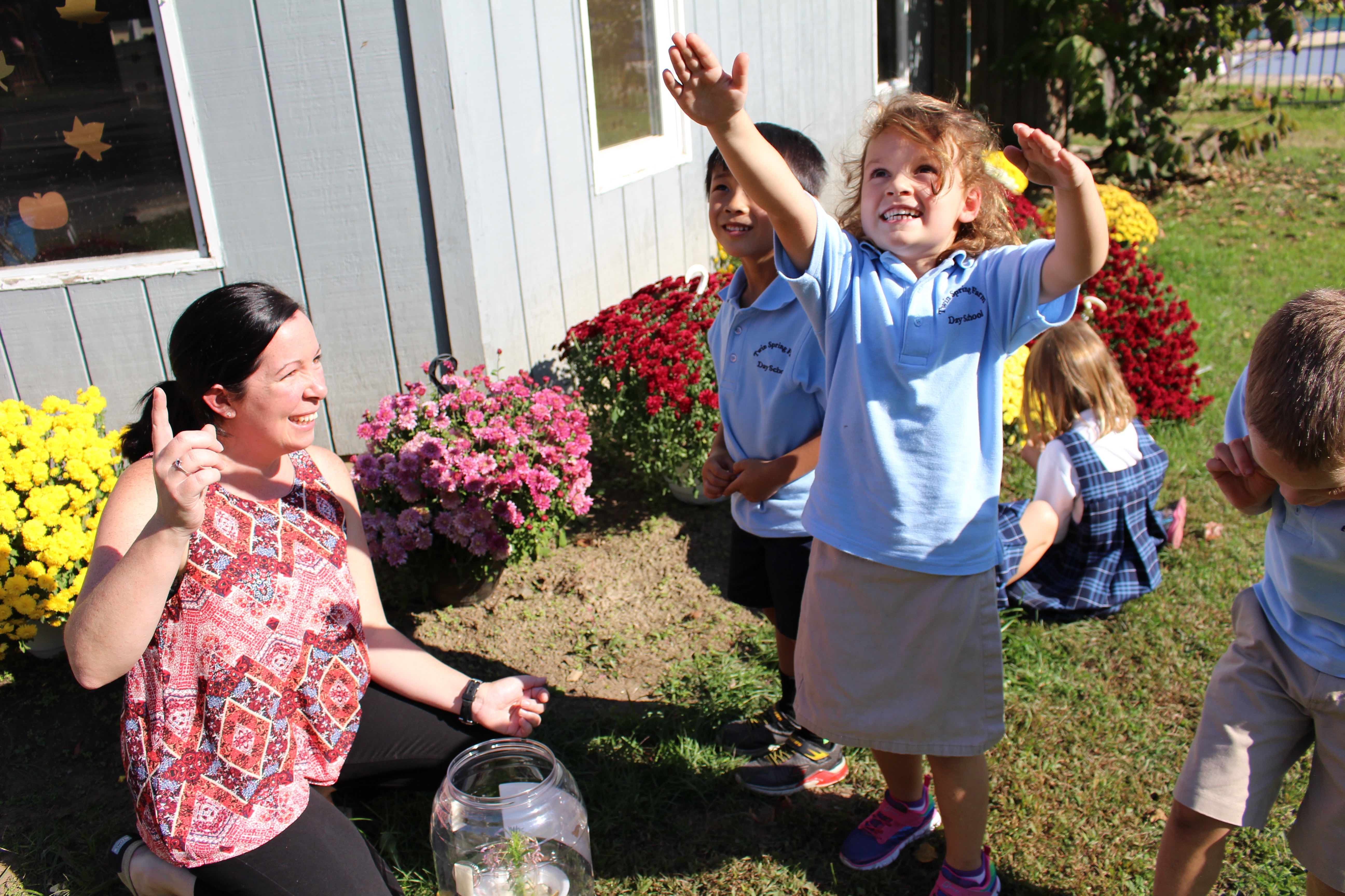 Children playing outside with a teacher.