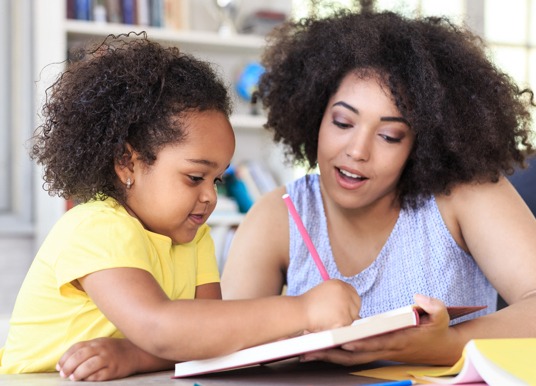 Teacher helping a student to write.