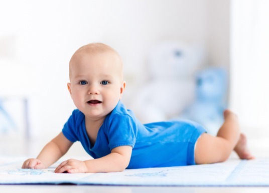 Infant boy lying on a table.