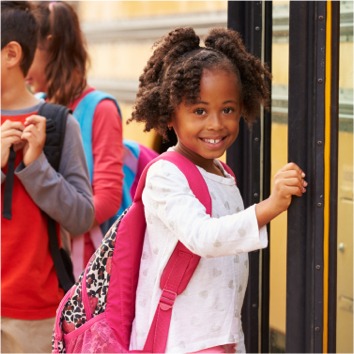 Young student getting on a bus.