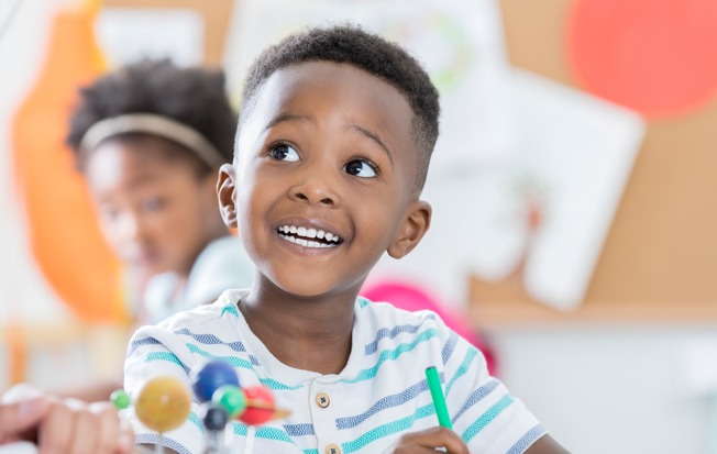 Boy toddler looking at a teacher.