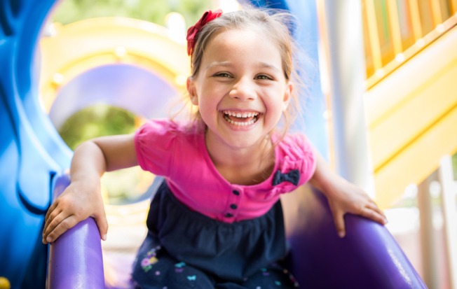 Young girl playing on a slide.