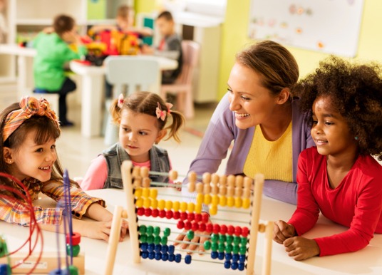 Young students working with a teacher.